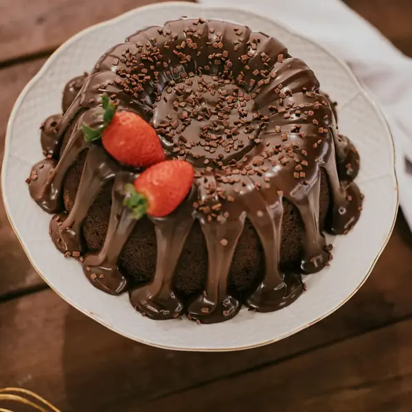Bolo caseiro de chocolate com calda e morangos