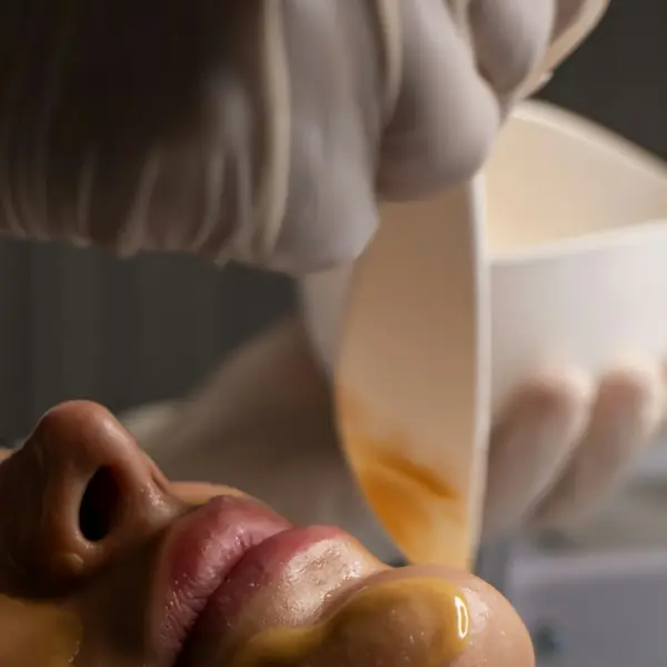 Esteticista aplica máscara facial com espátula