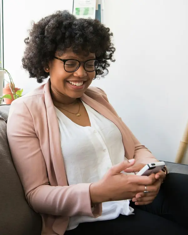 Empreendedora sorrindo enquanto olha o celular