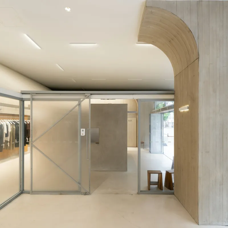 Interior da Loja Areia, com arco de concreto e divisórias de vidro